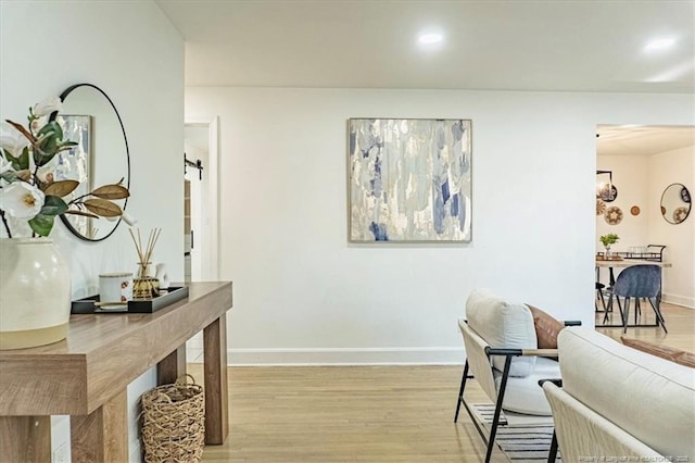 interior space featuring light wood-style floors, a barn door, and baseboards