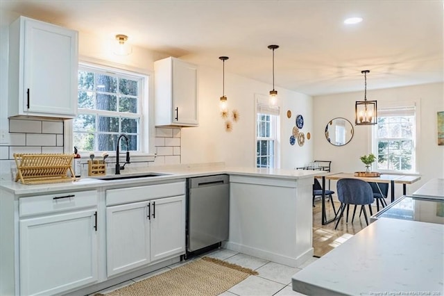 kitchen featuring a sink, white cabinets, dishwasher, and light countertops