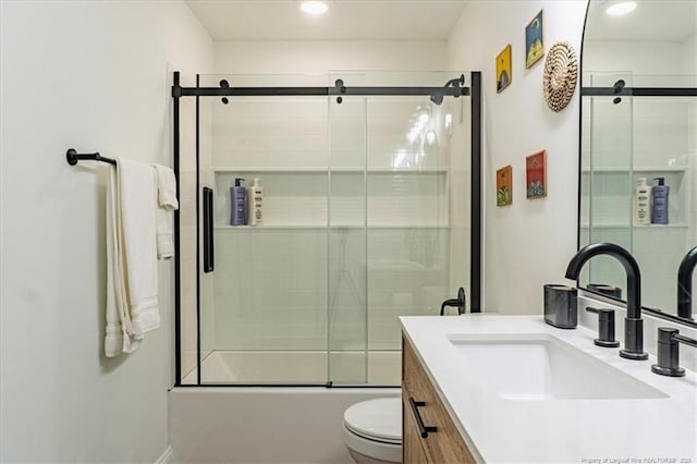 full bath with toilet, combined bath / shower with glass door, and vanity