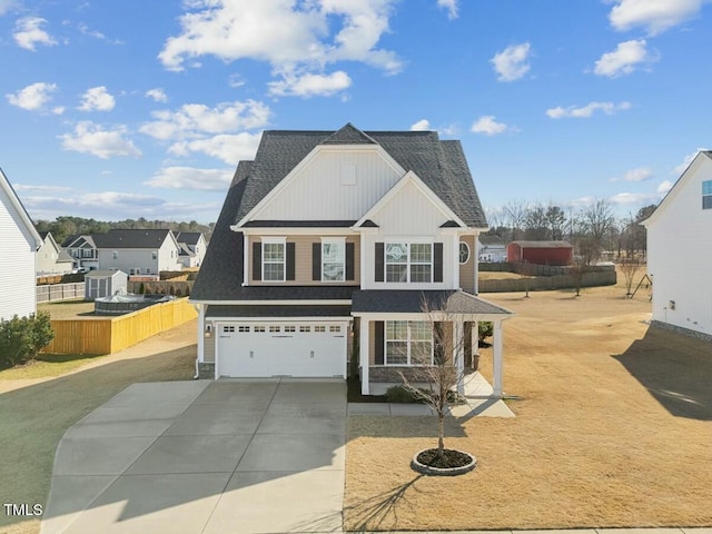 view of front facade with a shingled roof, concrete driveway, an attached garage, board and batten siding, and fence