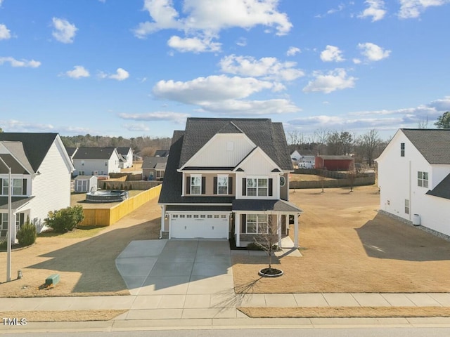 traditional-style home with driveway, an attached garage, a residential view, and fence