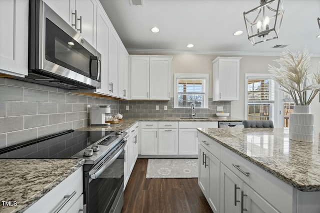 kitchen with dark wood-style floors, pendant lighting, appliances with stainless steel finishes, white cabinetry, and a sink