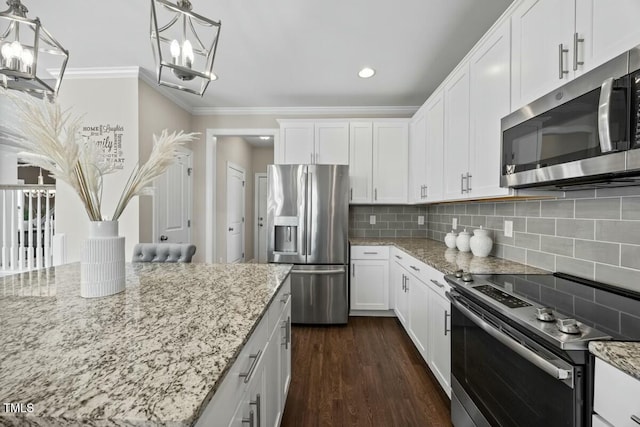 kitchen featuring light stone counters, decorative light fixtures, stainless steel appliances, crown molding, and white cabinetry