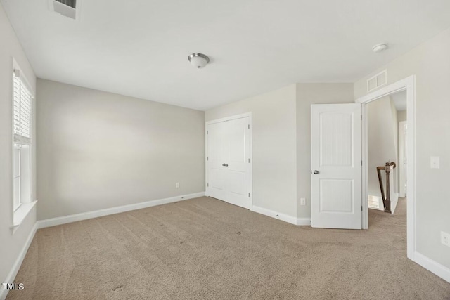 unfurnished bedroom featuring baseboards, visible vents, and carpet flooring