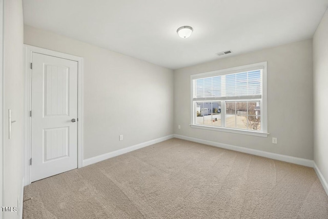 carpeted spare room featuring visible vents and baseboards