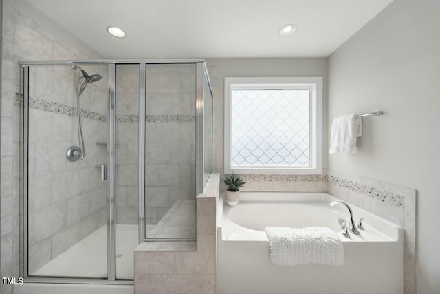 bathroom featuring a stall shower, a bath, and recessed lighting