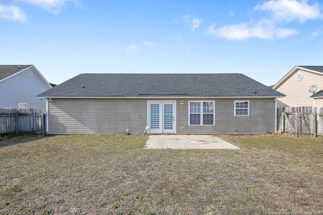 back of property featuring a patio, a yard, a shingled roof, and a fenced backyard