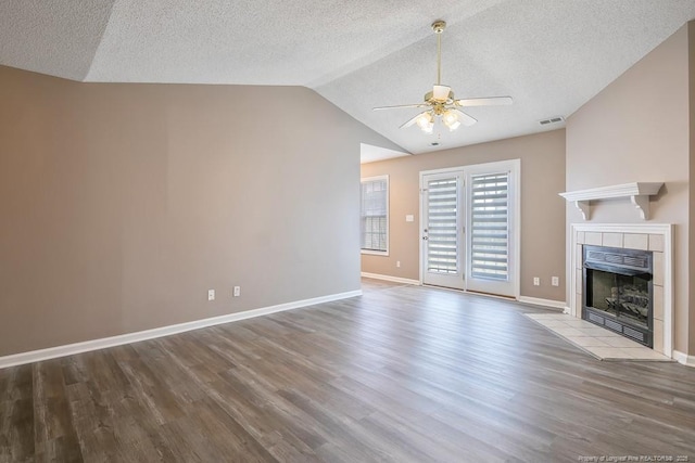 unfurnished living room featuring baseboards, ceiling fan, light wood-style flooring, vaulted ceiling, and a fireplace