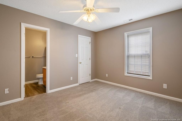 unfurnished bedroom featuring carpet floors, baseboards, visible vents, and connected bathroom