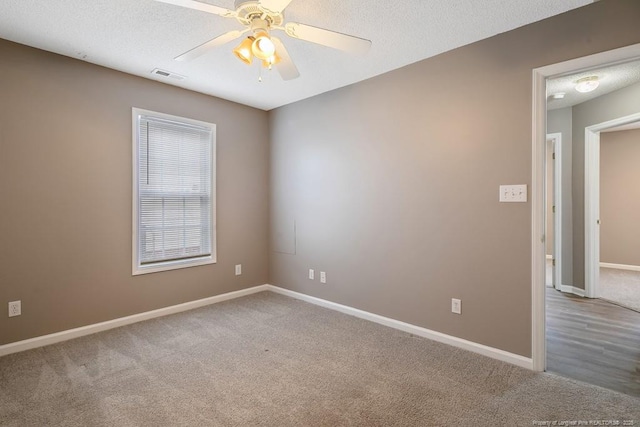 unfurnished room featuring visible vents, carpet flooring, and a textured ceiling