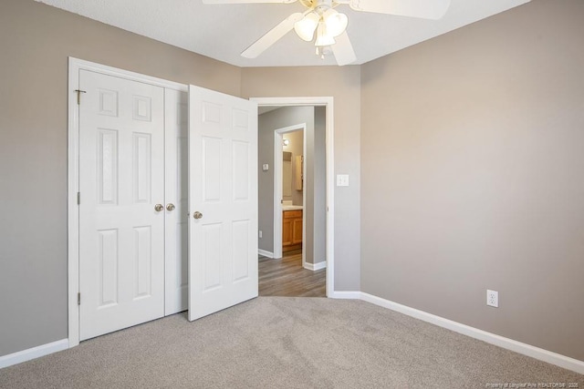 unfurnished bedroom with a closet, light carpet, ceiling fan, and baseboards