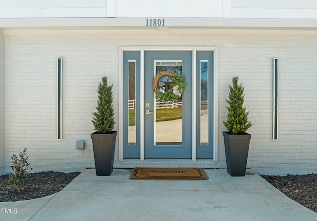 entrance to property featuring brick siding