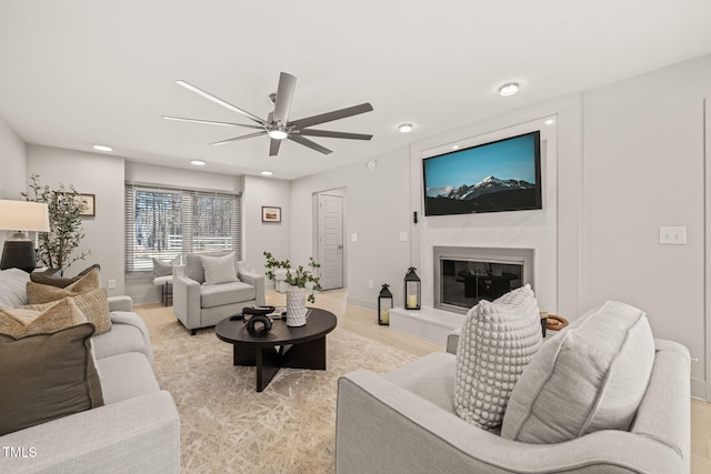 living area with ceiling fan, baseboards, a high end fireplace, and recessed lighting