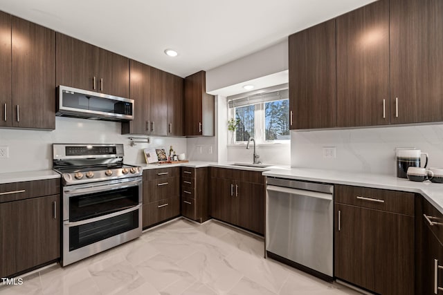 kitchen featuring light countertops, appliances with stainless steel finishes, and a sink