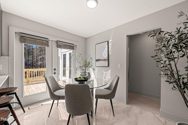 dining area with marble finish floor and baseboards