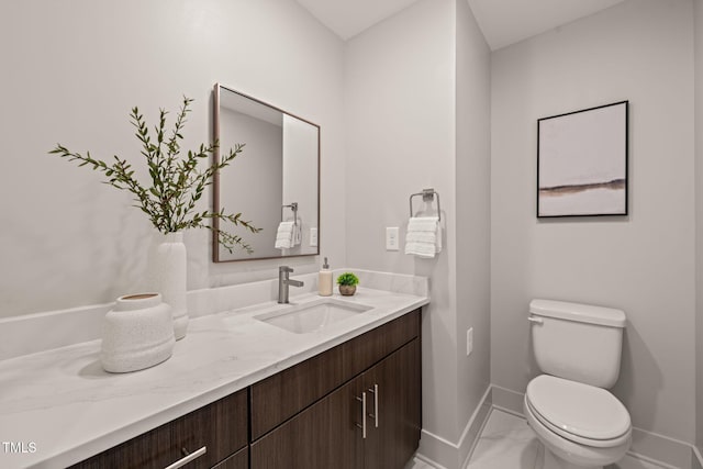 bathroom with toilet, baseboards, and vanity