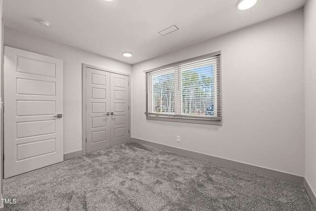 unfurnished bedroom with recessed lighting, a closet, carpet, and baseboards