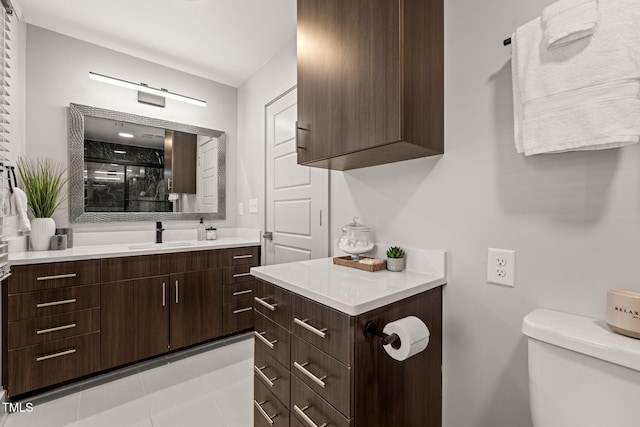 bathroom featuring tile patterned flooring, vanity, and toilet