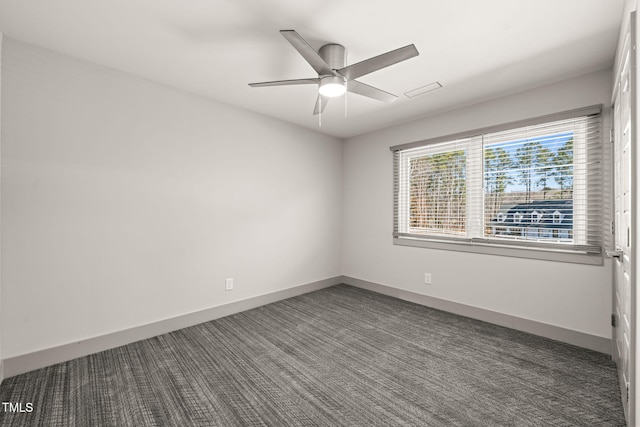 empty room with dark carpet, a ceiling fan, and baseboards