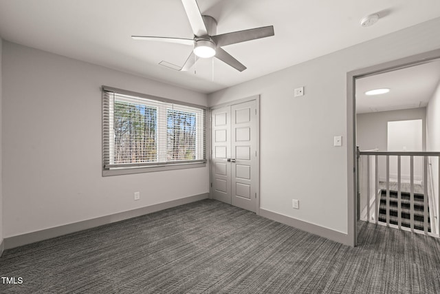 unfurnished bedroom featuring a ceiling fan, a closet, baseboards, and carpet flooring