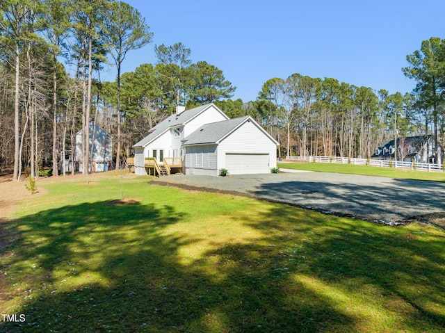 view of side of home featuring an attached garage, a shingled roof, fence, a yard, and a chimney