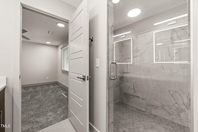 bathroom featuring recessed lighting, a marble finish shower, vanity, and baseboards