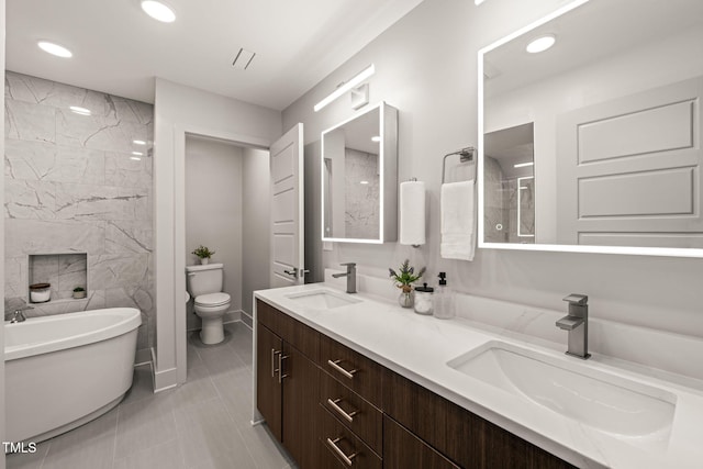 bathroom with a sink, a freestanding bath, toilet, and double vanity