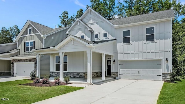 7521 Percussion Dr, Apex, NC 27539 - view of front of property with board and batten siding, an attached garage, covered porch, stone siding, and concrete driveway
