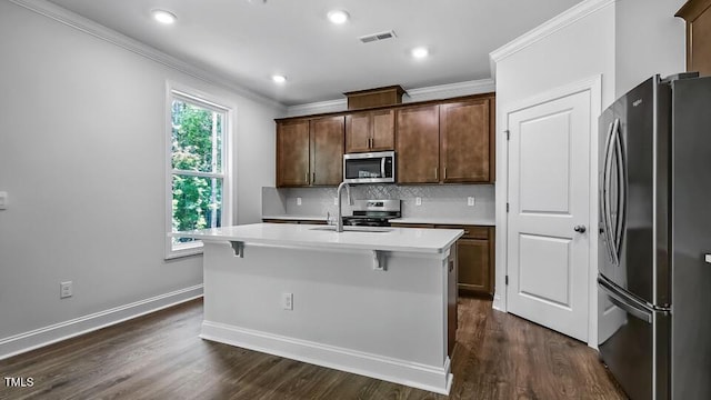 7521 Percussion Dr, Apex, NC 27539 - kitchen with stainless steel appliances, crown molding, light countertops, backsplash, and a kitchen island with sink