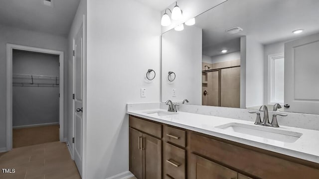 7521 Percussion Dr, Apex, NC 27539 - bathroom featuring a stall shower, double vanity, a spacious closet, and tile patterned flooring