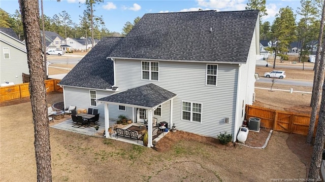 back of property with roof with shingles, a patio, central AC unit, a residential view, and a fenced backyard