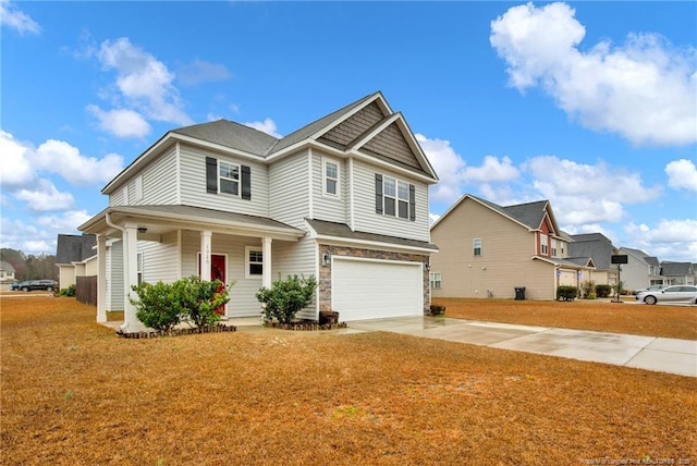 view of front facade with driveway, a garage, a porch, and a front yard