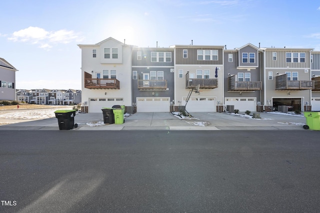 townhome / multi-family property featuring driveway, an attached garage, and a residential view