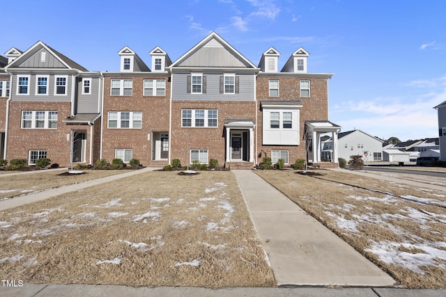 townhome / multi-family property featuring board and batten siding and brick siding