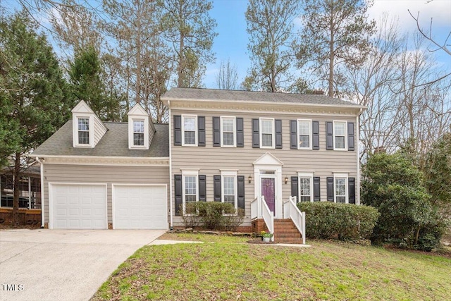 colonial house with a front lawn, concrete driveway, a garage, and a shingled roof