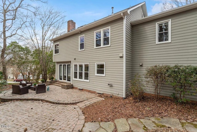 rear view of property with an outdoor hangout area, a chimney, and a patio area