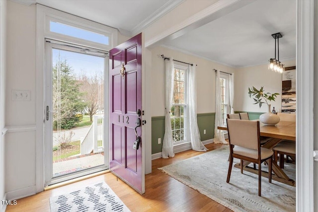 entrance foyer featuring baseboards, light wood-style floors, and crown molding