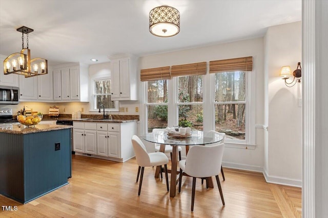 dining area featuring baseboards, a wealth of natural light, and light wood-type flooring