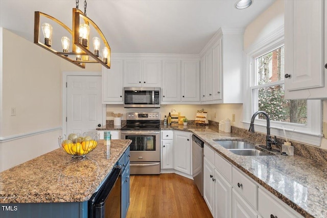 kitchen featuring white cabinets, blue cabinetry, stainless steel appliances, and a sink