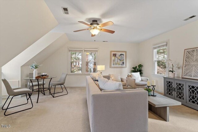 living room with visible vents, light carpet, baseboards, and ceiling fan