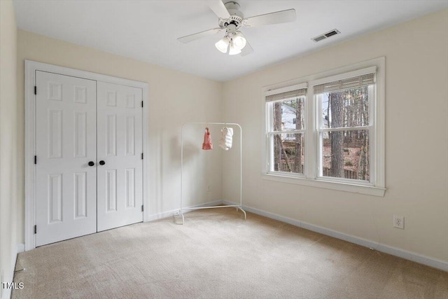 unfurnished bedroom with visible vents, ceiling fan, baseboards, carpet floors, and a closet