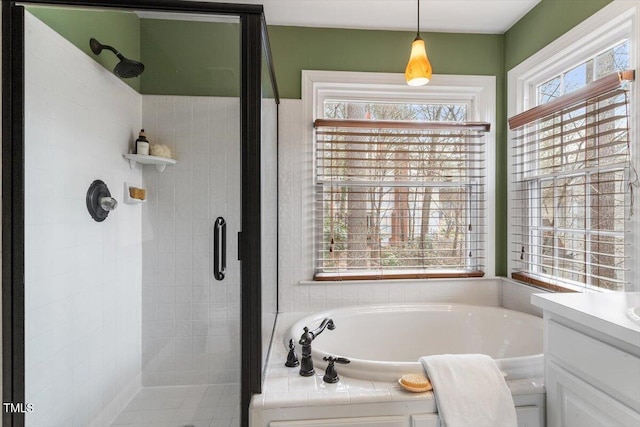 bathroom featuring a stall shower, vanity, and a bath