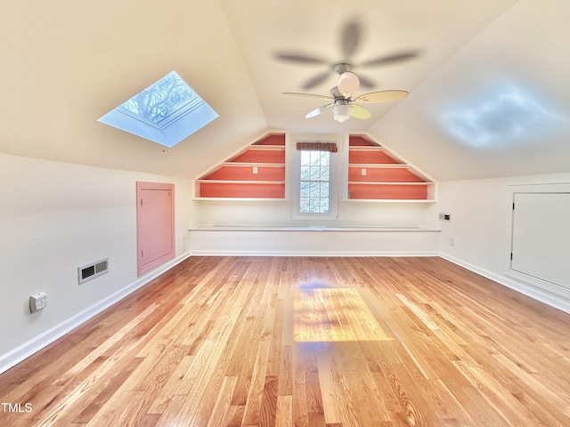 additional living space featuring visible vents, baseboards, vaulted ceiling, wood finished floors, and a ceiling fan