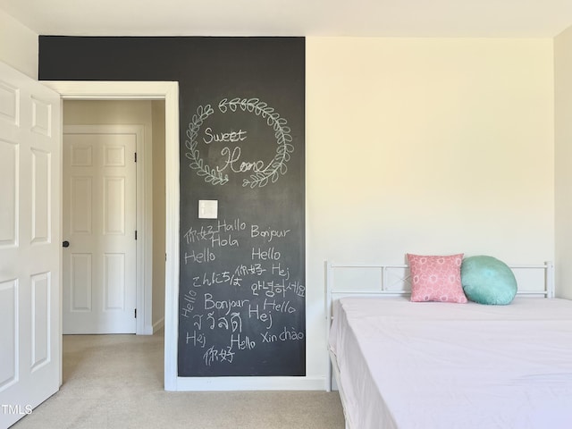 bedroom with baseboards and light carpet