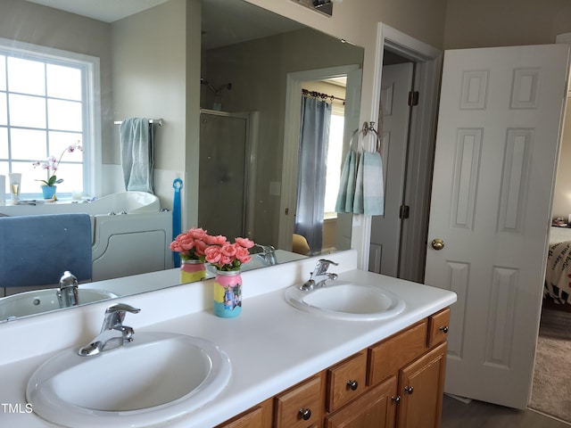 full bath with a stall shower, a sink, ensuite bathroom, and double vanity