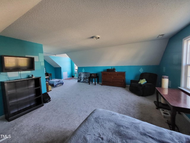 interior space featuring lofted ceiling, visible vents, and a textured ceiling