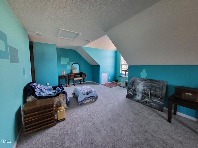 carpeted bedroom with attic access, baseboards, vaulted ceiling, and a textured ceiling