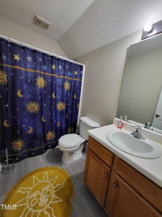 full bath with visible vents, toilet, vanity, a textured ceiling, and wood finish floors