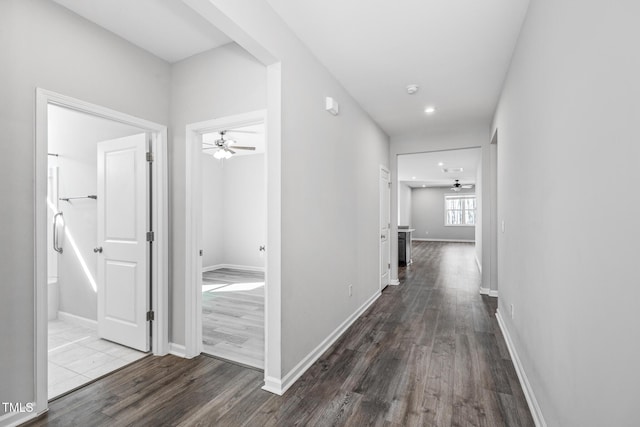 hallway with dark wood-style flooring, recessed lighting, and baseboards