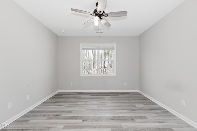 empty room featuring baseboards, a ceiling fan, and light wood-style floors